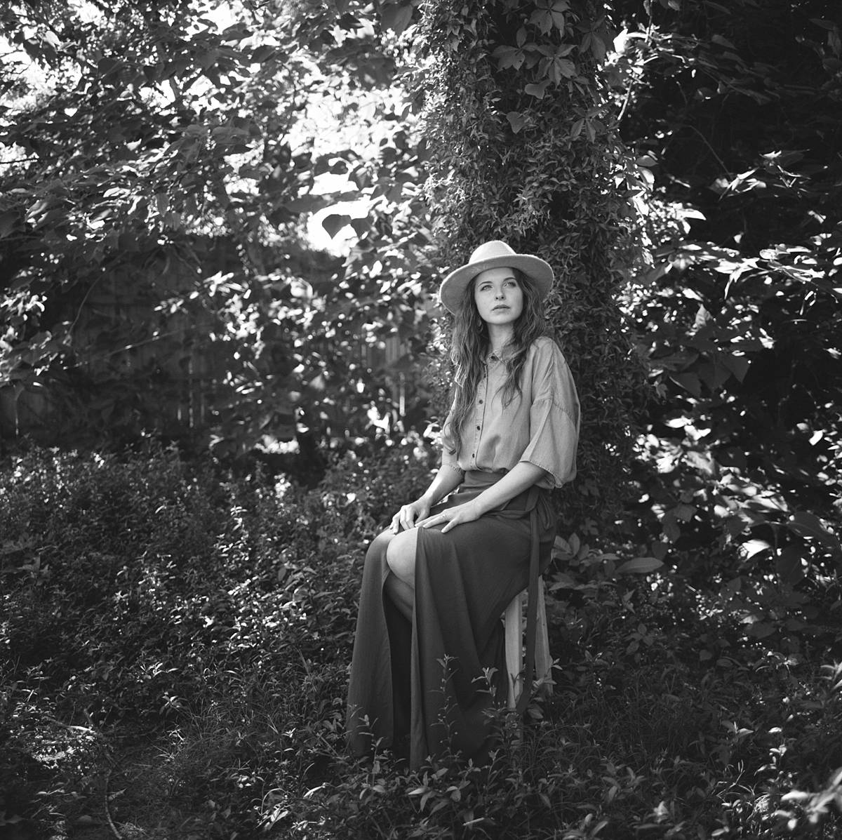 shallow depth of field portrait of girl under tree in outdoor studio taken with hasselblad 110mm F2 lens